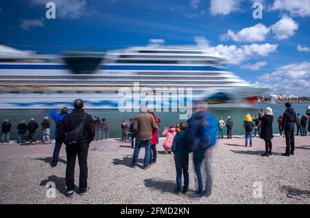 Rostock, Deutschland. Mai 2021. Die Bewohner der Hansestadt und Kreuzfahrtfans begrüßen das Kreuzschiff „AIDAsol“ bei der Einfahrt in den Hafen. Das Schiff kommt anlässlich der Nationalen Seeverkehrskonferenz am 10.05.2021 und der Einweihung des neuen Landkraftwerks nach Warnemünde. Quelle: Jens Büttner/dpa-Zentralbild/dpa/Alamy Live News Stockfoto