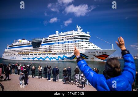 Rostock, Deutschland. Mai 2021. Die Bewohner der Hansestadt und Kreuzfahrtfans begrüßen das Kreuzschiff „AIDAsol“ bei der Einfahrt in den Hafen. Das Schiff kommt anlässlich der Nationalen Seeverkehrskonferenz am 10.05.2021 und der Einweihung des neuen Landkraftwerks nach Warnemünde. Quelle: Jens Büttner/dpa-Zentralbild/dpa/Alamy Live News Stockfoto