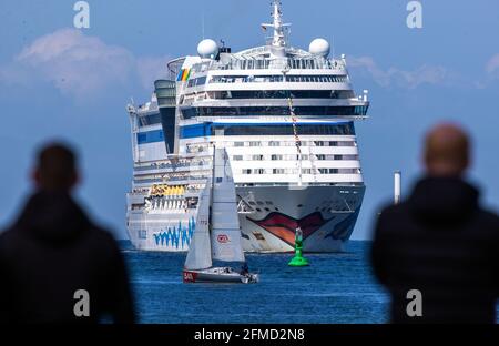 Rostock, Deutschland. Mai 2021. Die Bewohner der Hansestadt und Kreuzfahrtfans begrüßen das Kreuzschiff „AIDAsol“ bei der Einfahrt in den Hafen. Das Schiff kommt anlässlich der Nationalen Seeverkehrskonferenz am 10.05.2021 und der Einweihung des neuen Landkraftwerks nach Warnemünde. Quelle: Jens Büttner/dpa-Zentralbild/dpa/Alamy Live News Stockfoto