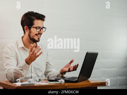 Junger kaukasischer Mann, der während der Arbeit in einen Videoanruf führt Büro Stockfoto