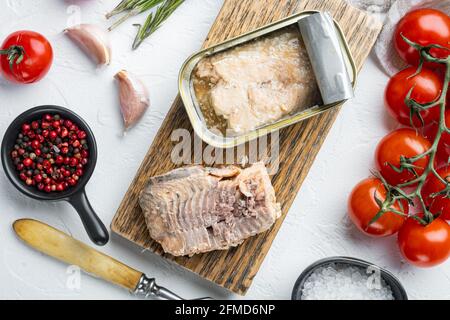 Set aus Wildrosa Lachs aus der Dose, auf Holzschneidebrett, auf weißem Hintergrund mit Kräutern und Zutaten, Draufsicht flach Stockfoto