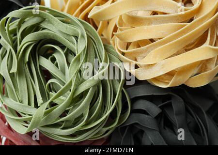 Verschiedene ungekochte mehrfarbige Pasta auf dem ganzen Hintergrund Stockfoto