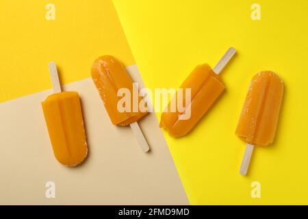 Mango- oder Karamell-Eis-Sticks auf farbigem Hintergrund Stockfoto