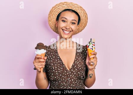 Schöne hispanische Frau mit kurzen Haaren essen Eiszapfen lächeln mit einem glücklichen und kühlen Lächeln auf dem Gesicht. Zeigt Zähne. Stockfoto