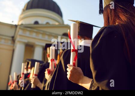Diplom-Zertifikat in der Hand der Absolventen stehen in der Schlange Rückansicht Stockfoto