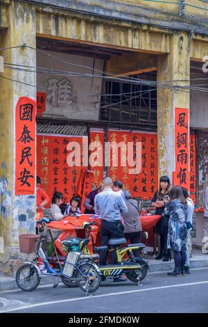 Foshan, Provinz Guangdong, China. FEBRUAR 8, 2021. Ein Kalligraph schreibt Frühlingsfest-Couplets für Menschen. Es ist der häufigste und wichtigste Kunde Stockfoto