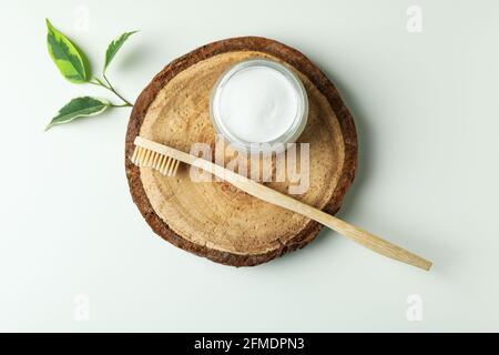 Brett mit umweltfreundlicher Zahnbürste und Zahnpulver auf weiß Hintergrund Stockfoto