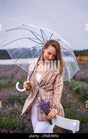 Frau geht in blühenden Feldern von Lavendel und genießt Größe der Natur. Flache Tiefe des Feldes Foto Stockfoto