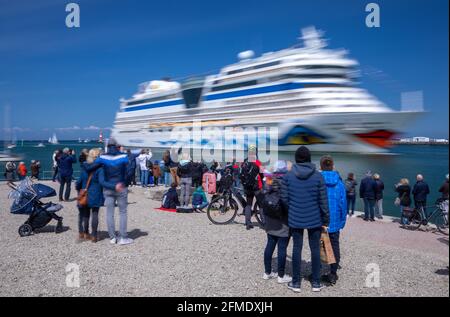 Rostock, Deutschland. Mai 2021. Die Bewohner der Hansestadt und Kreuzfahrtfans begrüßen das Kreuzschiff „AIDAsol“ bei der Einfahrt in den Hafen. Das Schiff kommt anlässlich der Nationalen Seeverkehrskonferenz am 10.05.2021 und der Einweihung des neuen Landkraftwerks nach Warnemünde. Quelle: Jens Büttner/dpa-Zentralbild/dpa/Alamy Live News Stockfoto