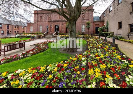 ARBROATH ANGUS SCHOTTLAND DAS BIBLIOTHEKSGEBÄUDE IM FRÜHJAHR MIT BUNTEN BLUMEN IM GARTEN Stockfoto