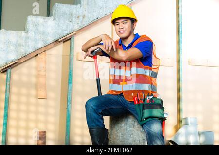 Asiatische indonesischen Bauarbeiter mit Helm und Warnweste auf einer Baustelle in Asien Stockfoto