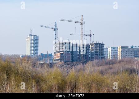 Kemerowo, Russland - 29. april 2021. Bau eines Rahmengebäudes mit Turmdrehkranen. Neues Gebäude des Steuerdienstes in der Stadt. SBER - unvollständige Beschriftung Stockfoto