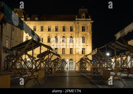 Ljubljana, Slowenien - 13. August 2020: Nachtansicht des leeren Marktes und des beleuchteten Stadthauses in Ljubljana Stockfoto