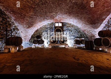 Alter gewölbter Weinkeller mit Fässern. Stockfoto