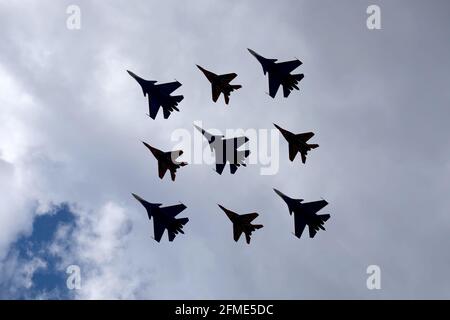 MOSKAU, RUSSLAND - 7. MAI 2021: Flugzeugsilhouetten von Kunstfluggruppen Russische Ritter und Swifts auf MIG-29- und SU-27-Kampfflugzeugen-Flügen auf Parade Stockfoto