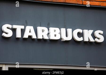 London, Großbritannien - 7. Mai 2021: Ein Schild über dem Eingang zu einem Starbucks Café im Zentrum von London, Großbritannien. Stockfoto