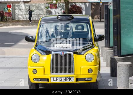 Gelbes und schwarzes Londoner Taxi in Imperial Wharf, Chelsea Harbour, Sands End, Borough of Hammersmith and Fulham, Greater London, England, Vereinigtes Königreich Stockfoto