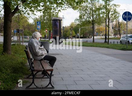 Warschau, Warschau, Polen. Mai 2021. Eine ältere Frau mit einer schützenden Gesichtsmaske sitzt auf einer Bank in der Nähe des Warschauer Parks der Königlichen Bäder, der am 8. Mai 2021 in Warschau, Polen, auch als Lazienki-Park bekannt ist. Quelle: Aleksander Kalka/ZUMA Wire/Alamy Live News Stockfoto