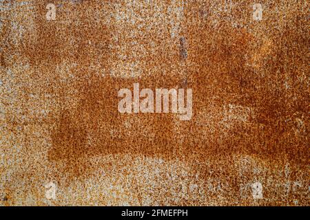 Abstrakter Hintergrund und Textur der weißen abblätternden Farbfläche mit orangen Rostflecken. Stockfoto