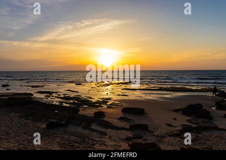 Draufsicht auf den Sonnenuntergang am Strand mit Felsen, Palmachim Strand, Israel Stockfoto