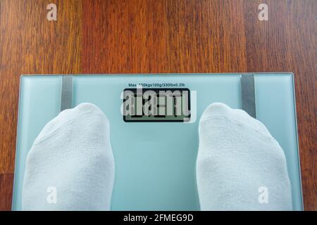 Badezimmerwaage zeigt die Ernährung auf dem digitalen Bildschirm an Die Person, die ihr Gewicht wiegt Stockfoto