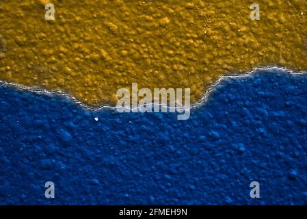 Blau und Gelb Orange Textur Hintergrund mit einem Crack. Meer Und Sand Konzept. Komplementärfarben. Chromatisches Kreisrad Stockfoto