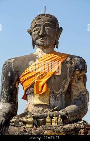 Nahaufnahme eines riesigen Steinstatuts von buddha, eingewickelt in orangene Uhrenmonasterie Phonsavan, Laos. Stockfoto