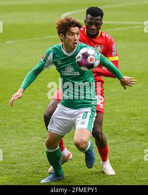 Bremen, Deutschland. Mai 2021. Osako Yuya (L) aus Bremen kontrolliert den Ball unter der Verteidigung von Edmond Tapsoba aus Leverkusen während eines Bundesliga-Spiels zwischen dem SV Werder Bremen und Bayer 04 Leverkusen in Bremen, Deutschland, 8. Mai 2021. Quelle: Ulrich Hufnagel/Xinhua/Alamy Live News Stockfoto