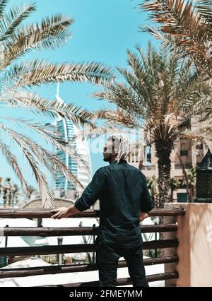 Junger Tourist in schwarzer Kleidung und mit moderner Frisur Genießt Sightseeing in Dubai in den Vereinigten Arabischen Emiraten Stockfoto