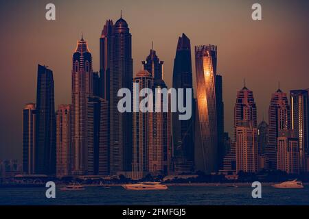 Wunderschöne Stadtlandschaft am Abend mit mildem Sunset Light. Luxuriöse moderne Wolkenkratzer stehen am Ufer der Bucht, wo Yachten festgemacht werden. Dubai. VAE. Stockfoto