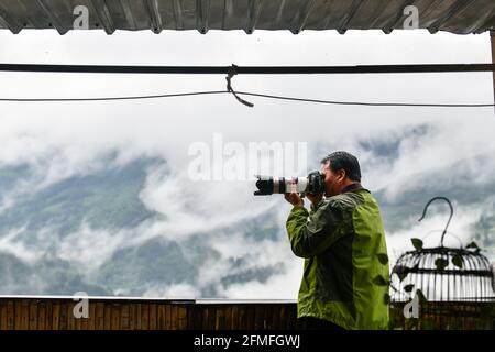 (210509) -- GUIYANG, 9. Mai 2021 (Xinhua) -- Mo Xiaoshu fotografiert terrassenförmig angelegte Felder in Jiabang im Bezirk Congjiang, südwestlich der chinesischen Provinz Guizhou, am 4. Mai 2021. An den meisten Morgen ist das Wetter auf den Terrassen mit einer Decke aus Wolken und Nebel bedeckt. Die verträumte Landschaft ist das, was man in Bildern von Mo Xiaoshu finden kann. Mo, ein 39-jähriger Beamter, hat in den letzten 13 Jahren mehr als 100,000 Fotos von terrassenförmig angelegten Feldern in Jiabang im Landkreis Congjiang gemacht. Seine Arbeit ging viral online und lockte viele Käferchen an, um die Reisterrassen zu besuchen. Jiabang ha Stockfoto