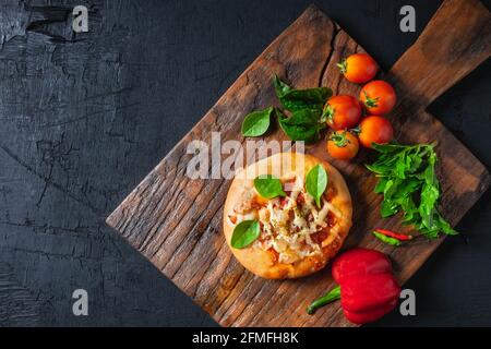 Pizza auf Holzpizzabrett Stockfoto