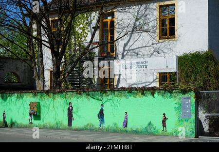 An der Wand vor dem Gemeindezentrum im Münchner Stadtteil Glockenbach, Graffiti und eine Kunstmaschine. Stockfoto