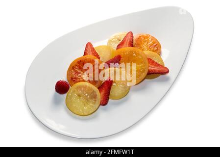 Zitronenscheiben, Orangen und Erdbeeren nach dem Kochen in Zuckersirup, um in einer weißen Schale kandiert zu werden Stockfoto