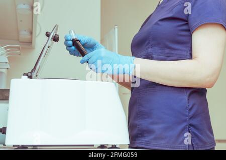 Arzt mit Reagenzgläsern an der Plasmazentrifuge Stockfoto