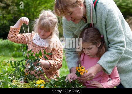 London, Großbritannien, 9. Mai 2021: Die Cousins Hippolita, 5 Jahre alt, und Minerva, 8 Jahre alt, machen die Blumenkronen, um den Garden Day zu feiern. Diese Veranstaltung fand im Chelsea Physic Garden statt und wurde von Floristin Fran Bailey von der Fresh Flower Company geleitet. Anna Watson/Alamy Live News Stockfoto