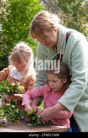 London, Großbritannien, 9. Mai 2021: Die Cousins Hippolita, 5 Jahre alt, und Minerva, 8 Jahre alt, machen die Blumenkronen, um den Garden Day zu feiern. Diese Veranstaltung fand im Chelsea Physic Garden statt und wurde von Floristin Fran Bailey von der Fresh Flower Company geleitet. Anna Watson/Alamy Live News Stockfoto