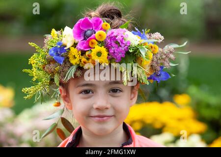 London, Großbritannien, 9. Mai 2021: Emelia, 5 Jahre alt, macht eine Blumenkrone, um den Garden Day zu feiern, und eine für den Teddybären der Klasse. Diese Veranstaltung fand im Chelsea Physic Garden statt und wurde von Floristin Fran Bailey von der Fresh Flower Company geleitet. Anna Watson/Alamy Live News Stockfoto