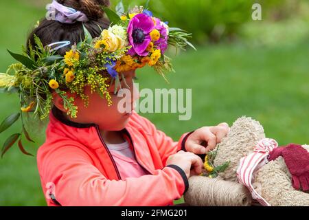 London, Großbritannien, 9. Mai 2021: Emelia, 5 Jahre alt, macht eine Blumenkrone, um den Garden Day zu feiern, und eine für den Teddybären der Klasse. Diese Veranstaltung fand im Chelsea Physic Garden statt und wurde von Floristin Fran Bailey von der Fresh Flower Company geleitet. Anna Watson/Alamy Live News Stockfoto