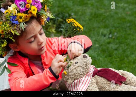 London, Großbritannien, 9. Mai 2021: Emelia, 5 Jahre alt, macht eine Blumenkrone, um den Garden Day zu feiern, und eine für den Teddybären der Klasse. Diese Veranstaltung fand im Chelsea Physic Garden statt und wurde von Floristin Fran Bailey von der Fresh Flower Company geleitet. Anna Watson/Alamy Live News Stockfoto