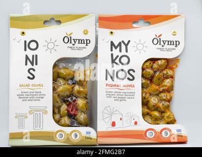 KIEW, UKRAINE - 06. MÄRZ 2021: Studio-Shooting von Ionis-Salat und Myconos grünen pikant marinierten griechischen ganzen Oliven mit rotem Pfeffer und Knoblauch Pack Clo Stockfoto