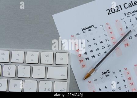 Nahaufnahme des Kalenders 2021 mit dem Stift von oben Mit Computertastatur Terminvereinbarung oder Zeitmanagement-Konzept Stockfoto