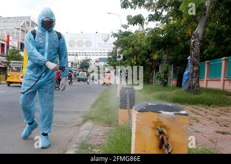 Phnom Penh. Mai 2021. Am 9. Mai 2021 sprüht ein Mitarbeiter des Gesundheitswesens Desinfektionsmittel vor einem COVID-19-Behandlungszentrum in Phnom Penh, Kambodscha. Die Zahl der Todesfälle in Kambodscha durch COVID-19 ist am Sonntag auf 120 angestiegen, nachdem in den letzten 24 Stunden sechs neue Todesfälle gemeldet wurden, teilte das Gesundheitsministerium in einer Erklärung mit. Quelle: Phenarum/Xinhua/Alamy Live News Stockfoto