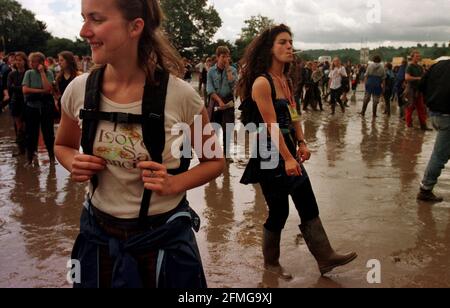 Glastonbury Music Festival 1998. Festivalbesucher laufen in tiefem Schlamm um die wasserdurchnässte Stätte herum Stockfoto