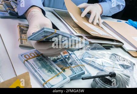 Spezialisierter Polizist notiert Dollar Banknote Referenz eines Raubes, konzeptuelle Bild Stockfoto