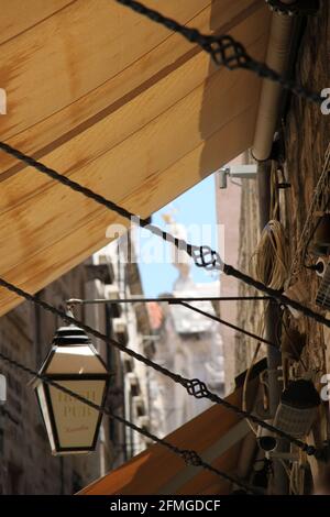 Kneipenlampe mit Baldachin und Eisenwerk in einer Seitenstraße in Dubrovnic, Kroatien Stockfoto