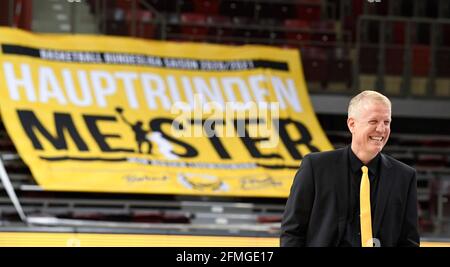 Ludwigsburg, Deutschland. Mai 2021. Basketball: Bundesliga, MHP Riesen Ludwigsburg - FC Bayern München, Hauptrunde, 34. Spieltag: Ludwigsburgs Trainer John Patrick lacht nach dem Spielende vor einem Plakat mit der Aufschrift 'Hauptlunden Meister'. Quelle: Thomas Kienzle/dpa/Alamy Live News Stockfoto