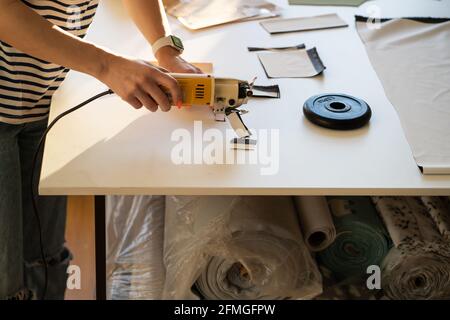 Professionelle maßgeschneiderte Kleidung Design Proben mit Cutter auf dem Tisch im Modestudio, Nahaufnahme Stockfoto