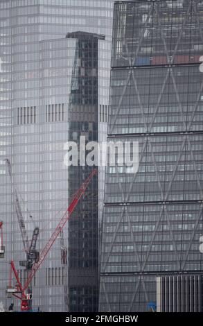 Glasverkleidungen von 22 Bishopsgate und 122 Leadenhall Street, The Cheesegrater, in der City of London, Mai 2021 mit Baukräne Stockfoto