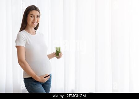 Prenanal-Vitamine. Glückliche Junge Werdende Frau Hält Glas Mit Grünem Gemüse Smoothie Stockfoto